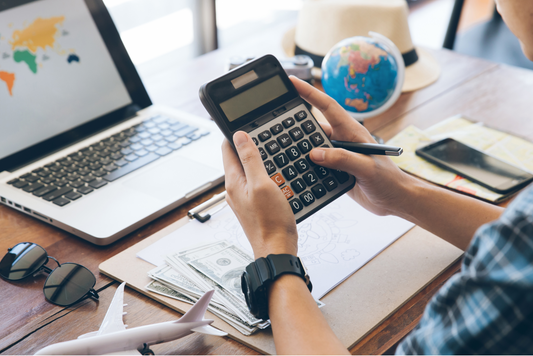 A man holding a calculator at his desk